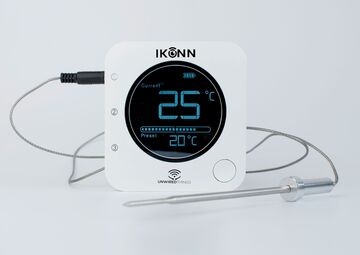 Ansicht auf ein weißes Thermometer mit schwarzer Anzeige.
