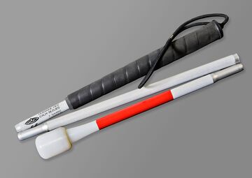 Ansicht auf einen Blindenlangstock mit schwarzem Griff und Reflexfolie