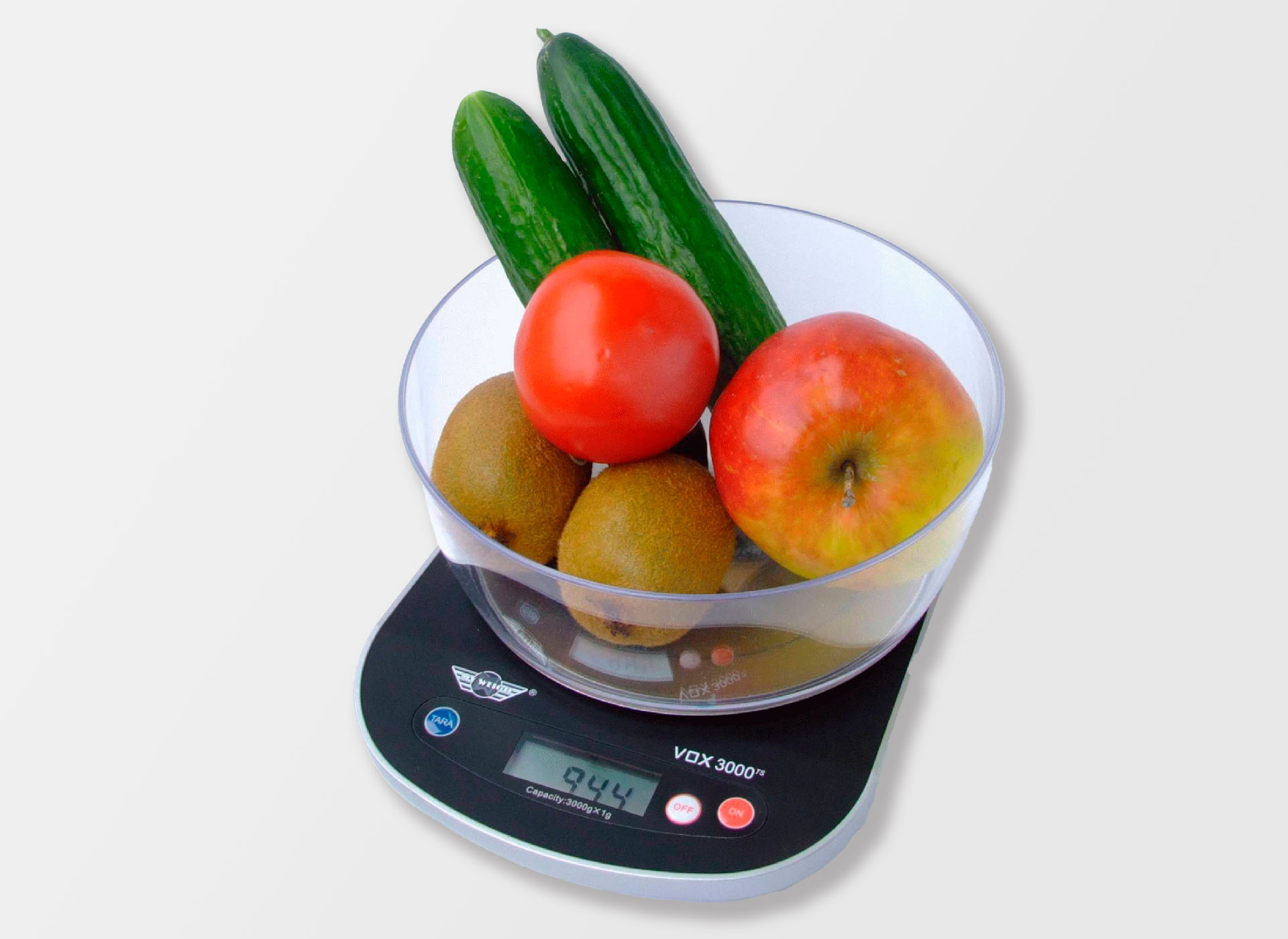 Ansicht auf die scharze Waage mit kleinem Display und einer Glasschale mit Obst und Gemüse.