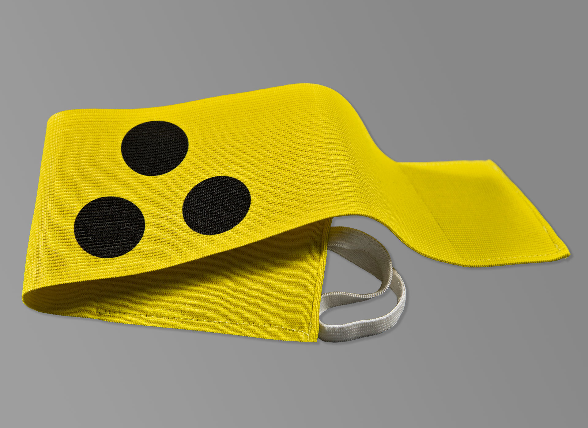 Gelbe Armbinde mit drei schwarzen Punkten.