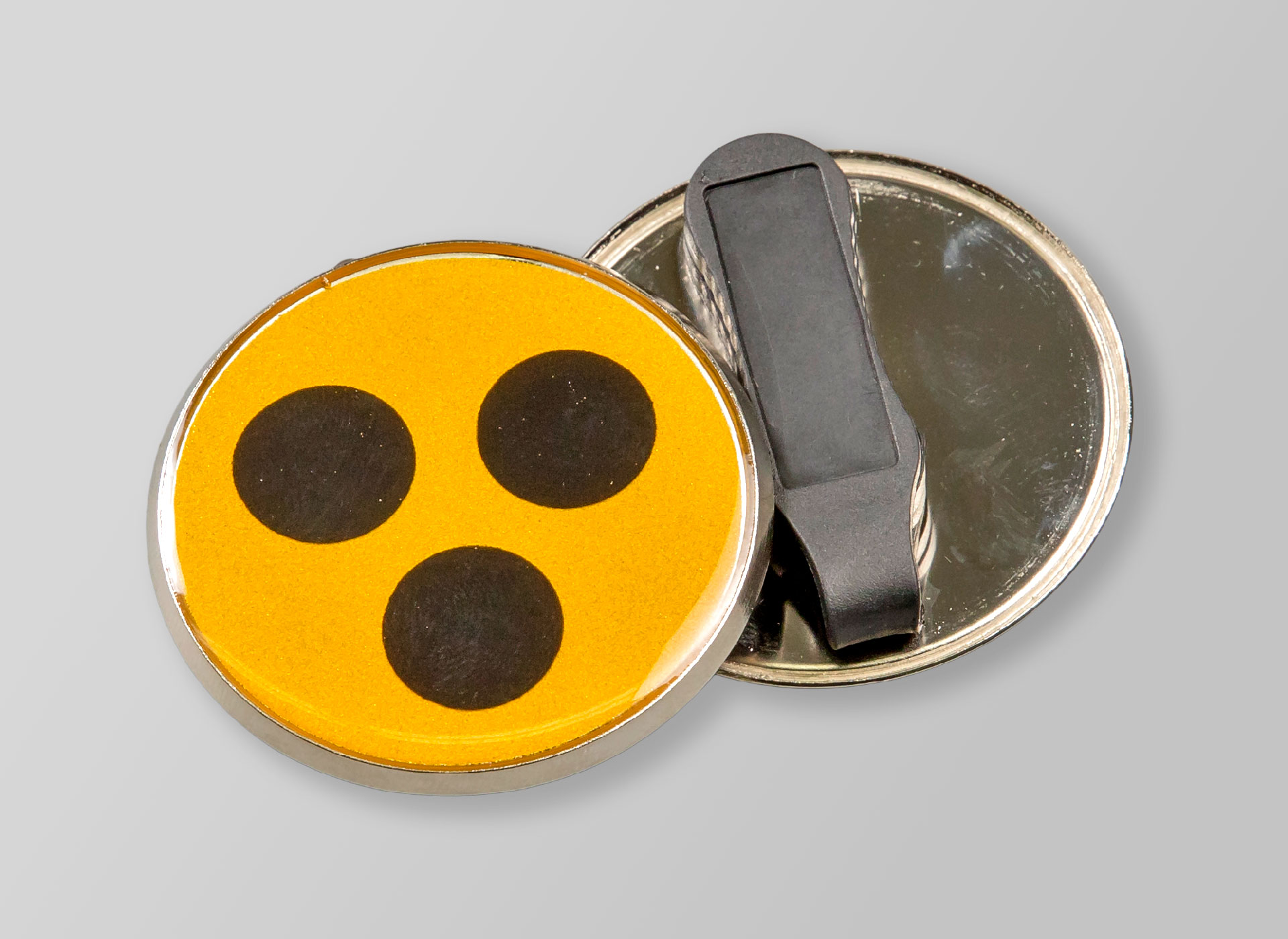 Ansicht auf eine gelbe Plakette mit drei schwarzen Punkten