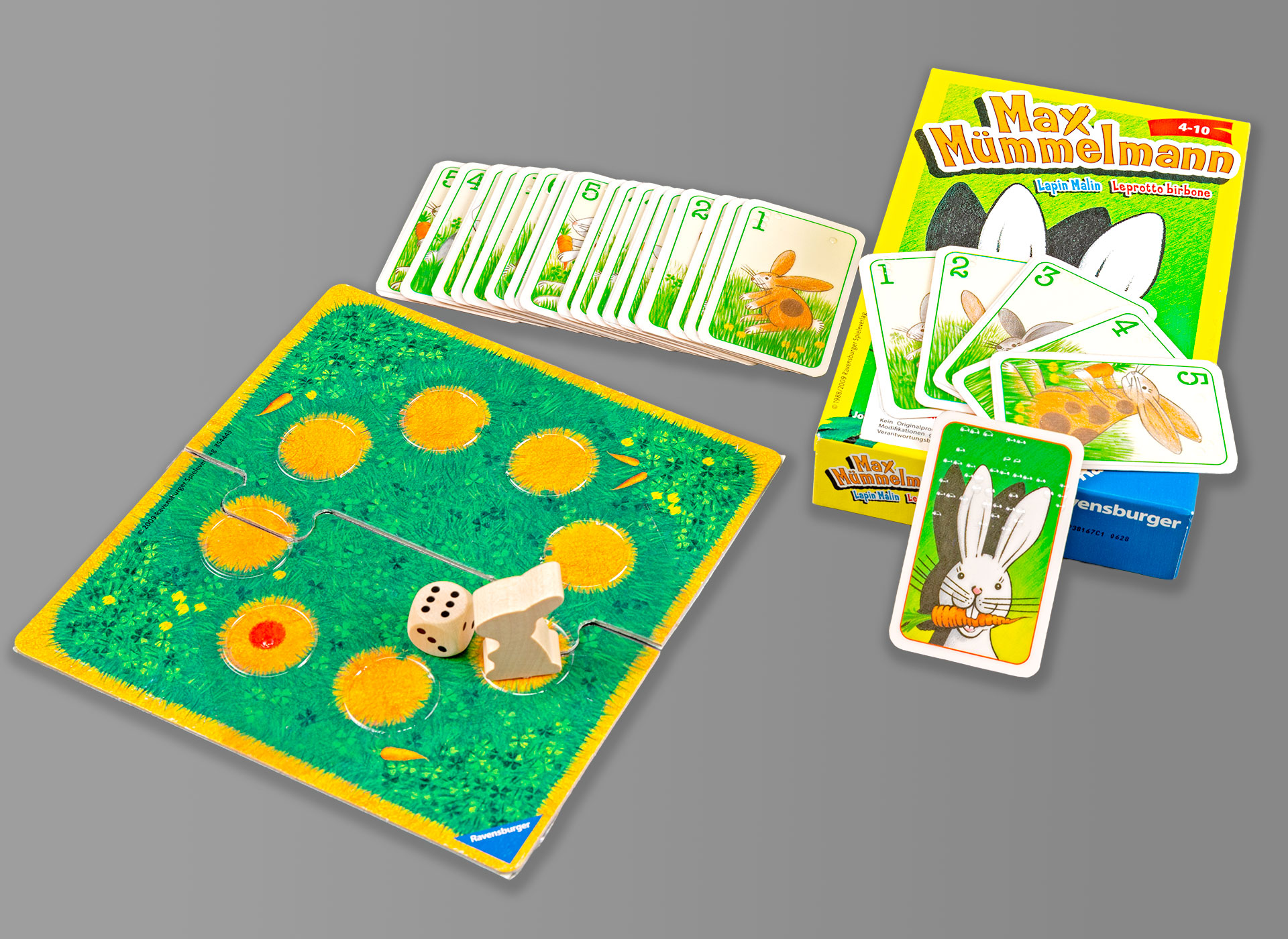 Ansicht auf das aufgebaute Spiel mit Karten, Karton und Spielbrett.