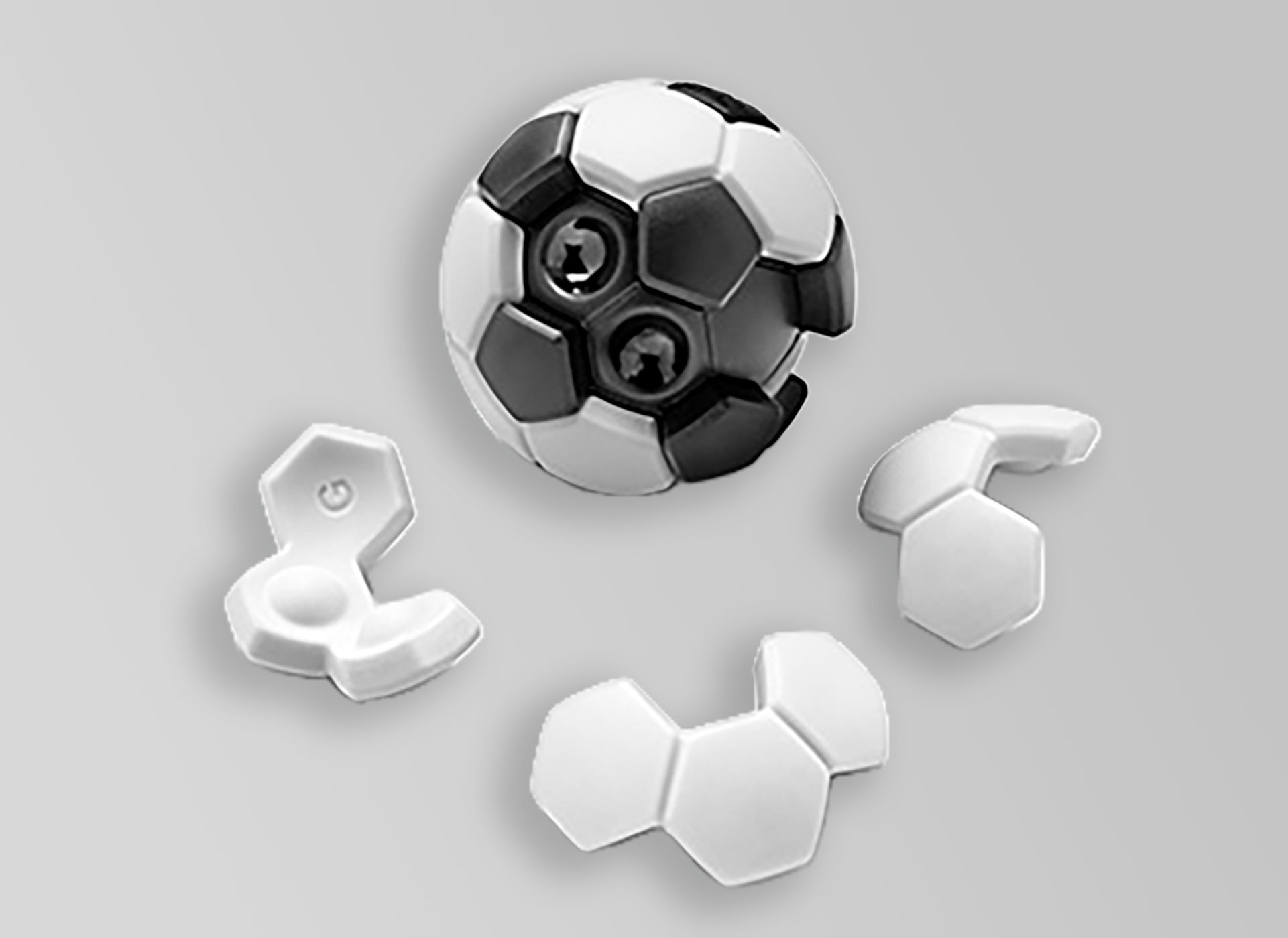 Ansicht auf das Logikspiel in Form eines Fußballs mit drei verschiedenen Spielsteinen im Vordergrund